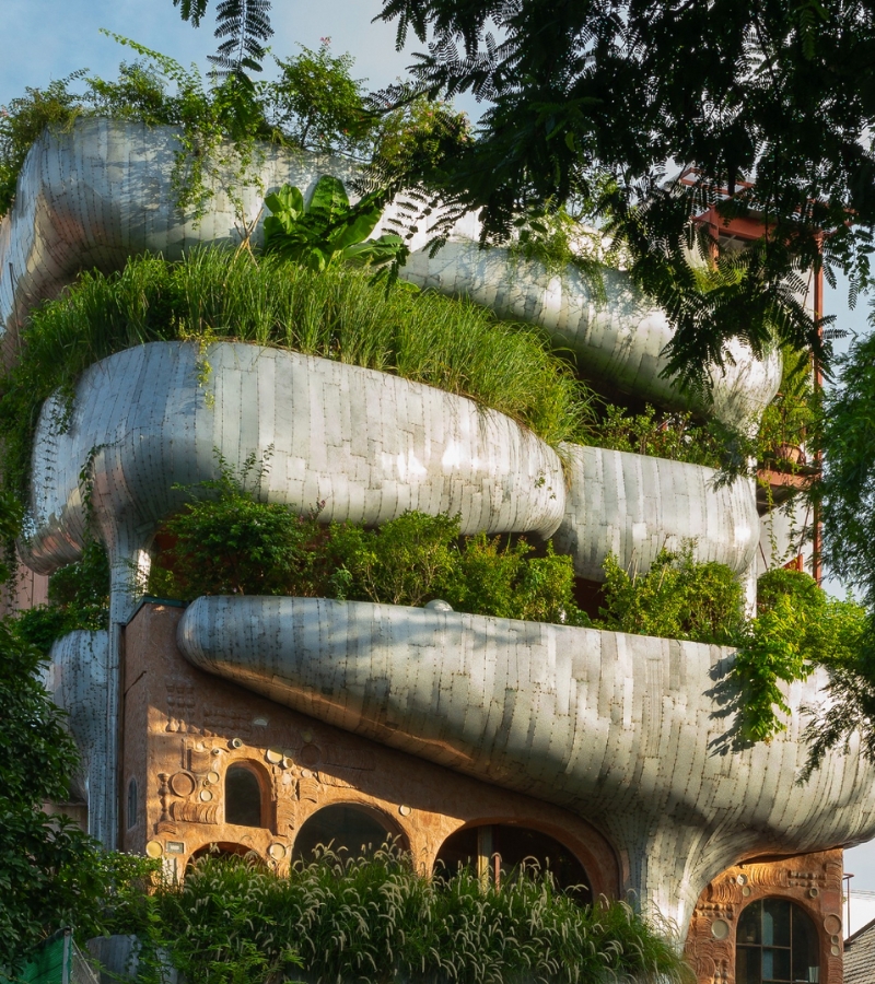 HUM - Un grand bâtiment se distingue par ses jardinières luxuriantes sur la rue Võ Văn Tần