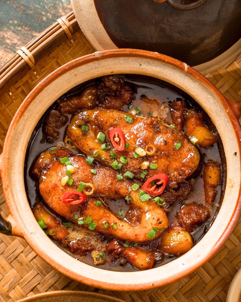 Poisson braisé à la sauce caramel (Ca kho to), mijoté lentement dans une marmite en terre cuite pour une saveur riche et parfumée